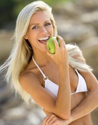 una niña come una manzana para bajar de peso en 10 kg por mes